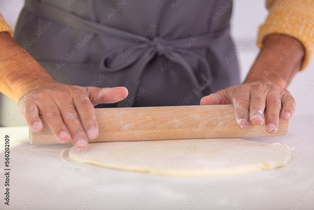 closeup image of man with rolling pin making tart