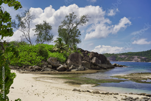 Mahe Seychelles, beach with rock formations and white sand. blue sky and low tide