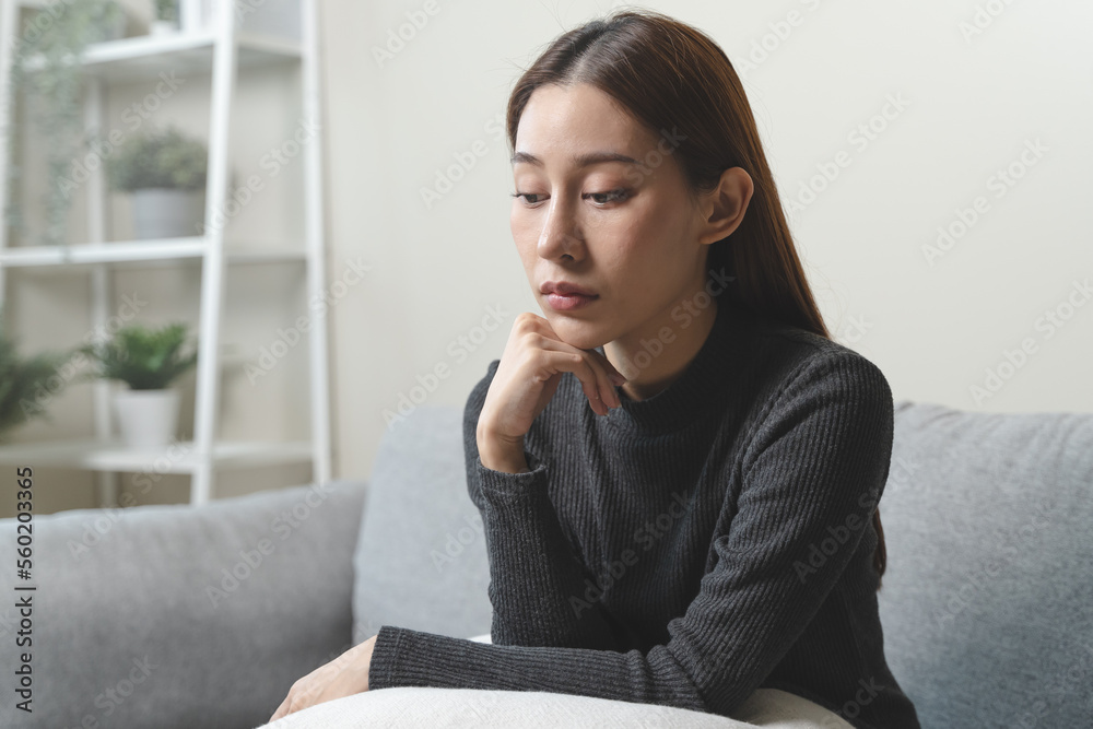Unhappy anxiety young Asian woman covering her face with pillow on the cough in the living room at home. Unhappy anxiety young Asian woman covering her face with pillow on the cough in the living room at home.