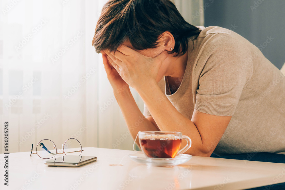 Depressed adult woman covers her face with her hands, cries, feels despair, grief, bad news Depressed adult woman covers her face with her hands, cries, feels despair, grief, bad news