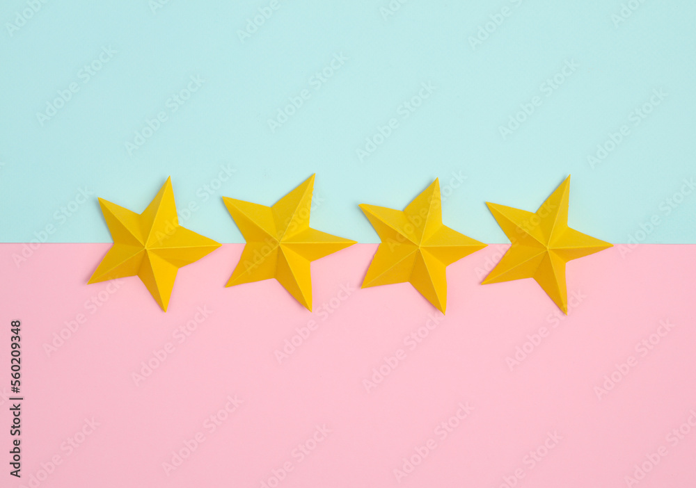 Four origami paper stars on pink blue pastel background. Service rating Four origami paper stars on pink blue pastel background. Service rating