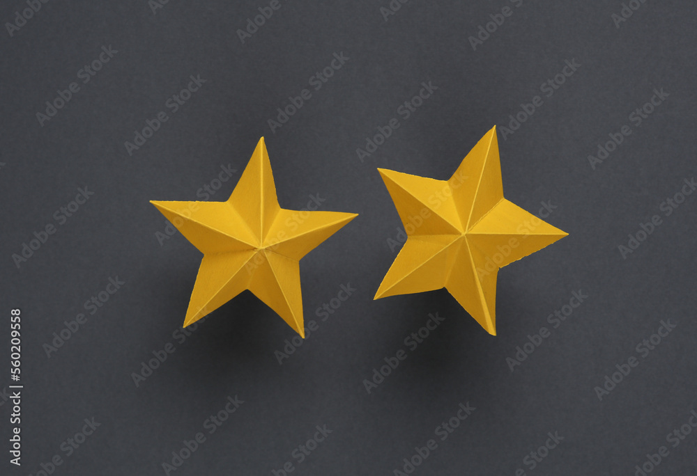 Two paper stars on gray background. Service rating Two paper stars on gray background. Service rating