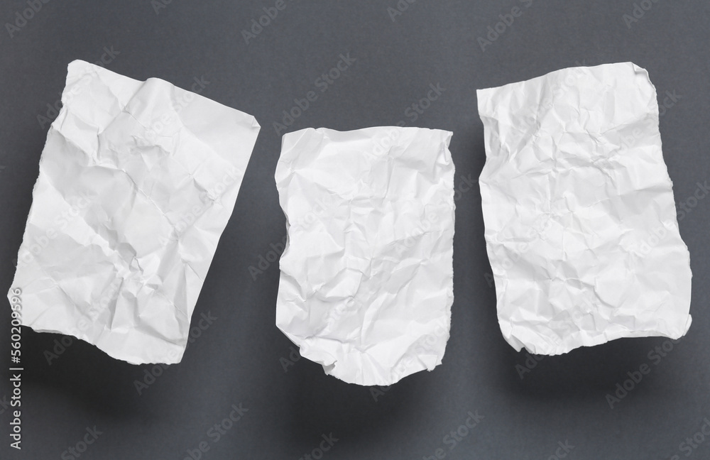 White crumpled piece of papers on gray background