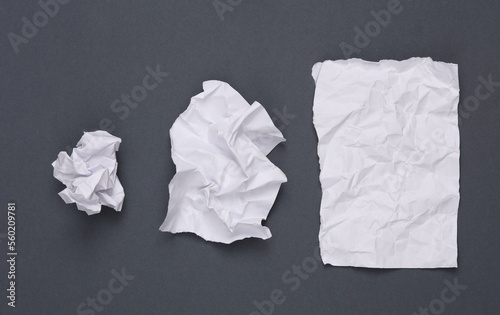 Step by step process of crumpling paper into a ball on gray background photo