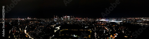 London business district panorama  Canary Wharf cityscape at night  glittering residential towers  skyscrapers  and modern buildings rising on the skyline  aerial view.