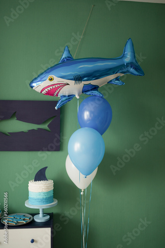 Home decoration of a children's holiday in the style of a shark, balloons and sweet pastries for children photo