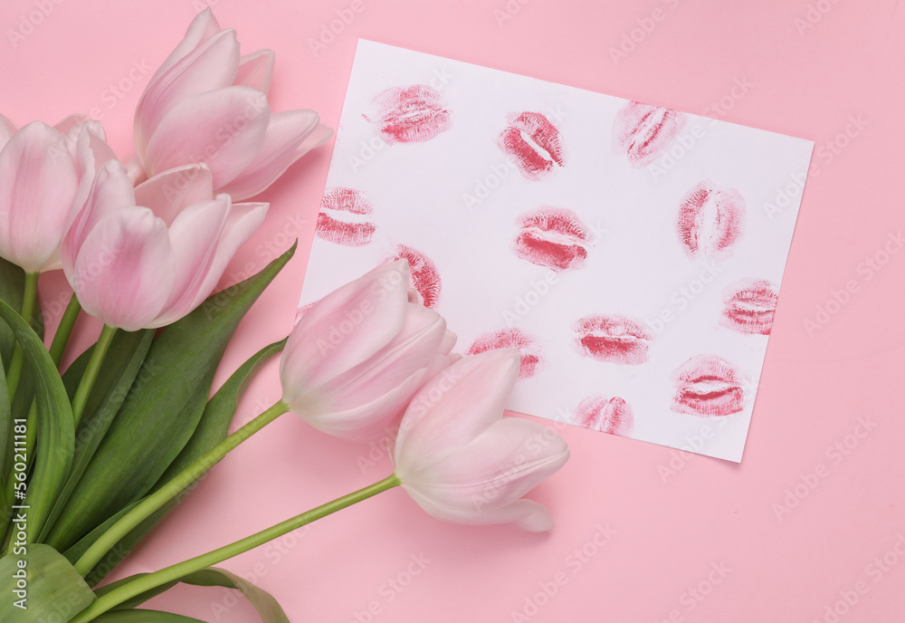 Lip print left by lipstick on white paper and tulips on pastel purple background. Valentine's day concept. Top view