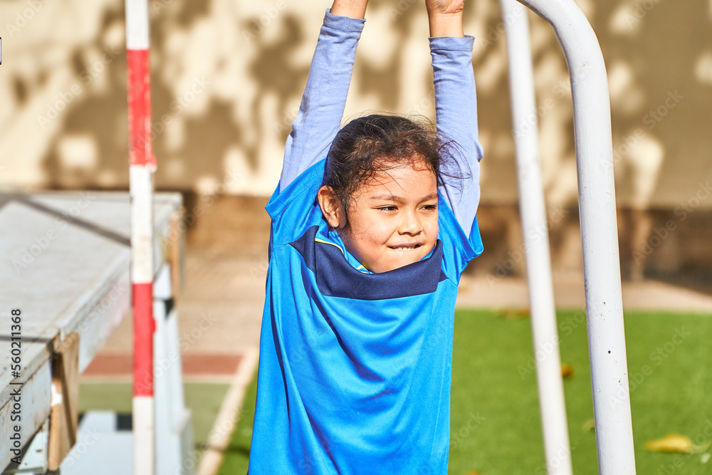 Fototapeta premium latin girl football player in a sport suit balancing on a soccer goal