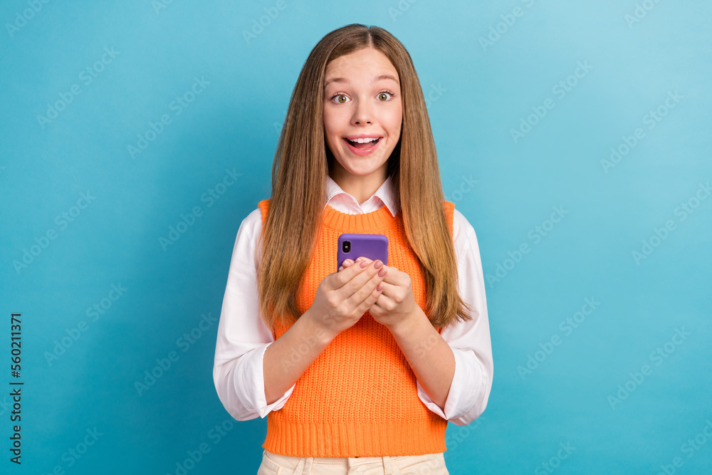 Portrait of astonished cheerful person hold telephone toothy smile isolated on blue color background Portrait of astonished cheerful person hold telephone toothy smile isolated on blue color background
