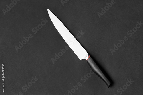 Large kitchen knife on a black background top view
