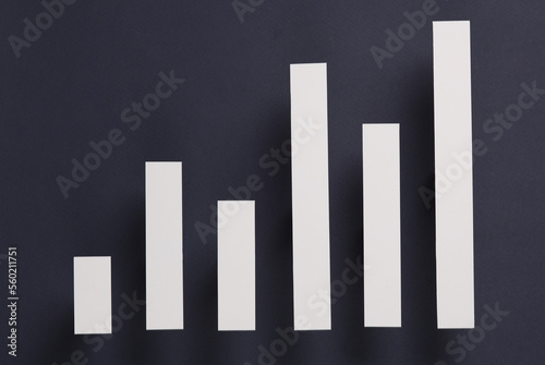 Paper-cut columns of a chart tending upwards on a gray background. Economic growth, analytics, business concept © splitov27