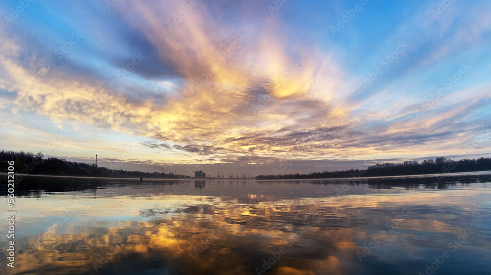 Sunrise over Danube river with silhouette of cranes in cargo port