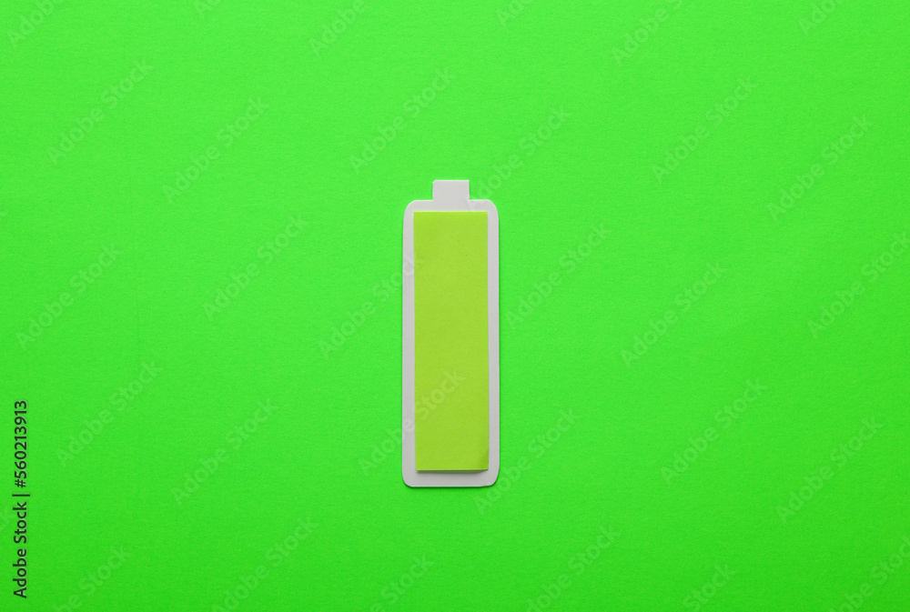 Paper-cut battery with a full charge level on green background Paper-cut battery with a full charge level on green background