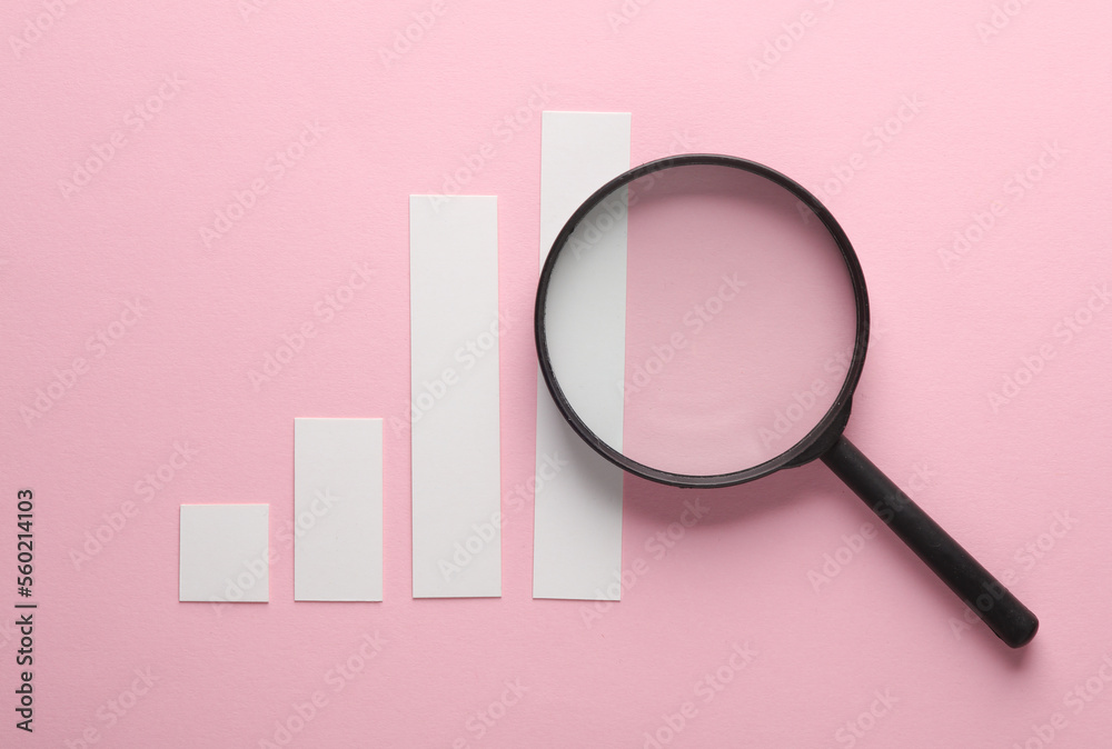 Bar chart with magnifier on pink background. Business concept Bar chart with magnifier on pink background. Business concept