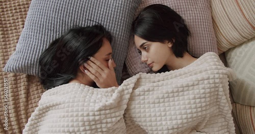 Couple of women hug each other warmly and relax at home in the bedroom. Lgbt and lesbian women at home. Embrace and holding each other. Friendship concept. Lifestyle and relationships. photo