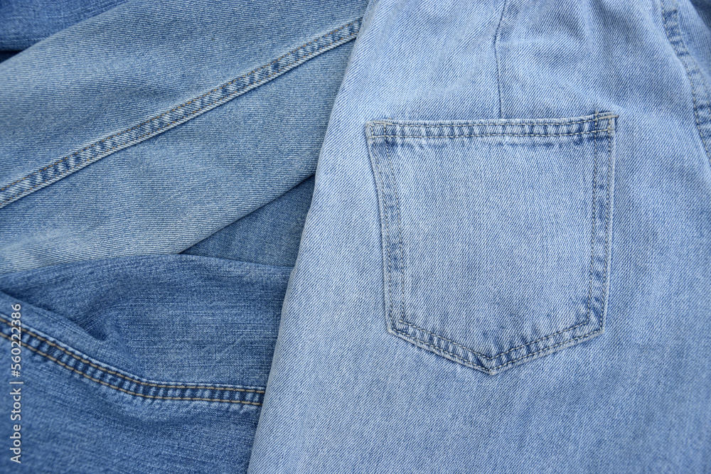 Fototapeta premium Lots of jeans pants in a stack. Denim background.