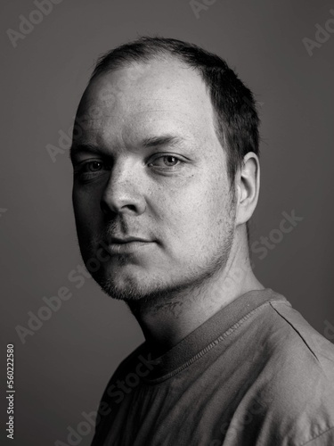 black and white commercial portrait of a finnish nordic caucasian man looking at the camera with short hair and freckels wearing a tshirt