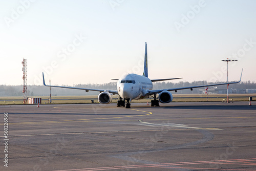 Passenger plane on a long parking lot in a small airport, morning light.