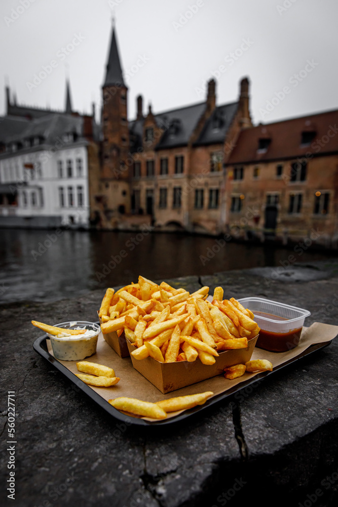 Fototapeta premium French fries on the background of the canal in Bruges, Belgium