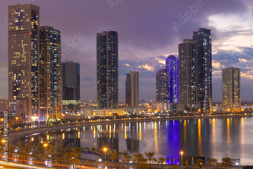 Sharjah city in uae cityscape at sunset in a cloudy day  with lake view