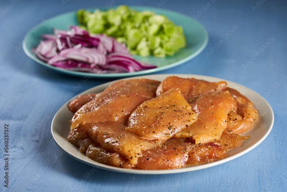 Seasoned chicken breast fillets on a plate Seasoned chicken breast fillets on a plate