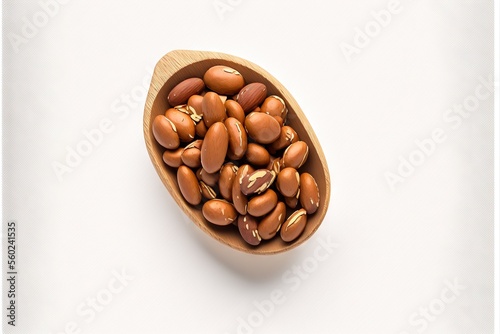  a wooden spoon filled with nuts on top of a white table top next to a white wall and a white background behind it is a wooden spoon with nuts in it and a wooden spoon.