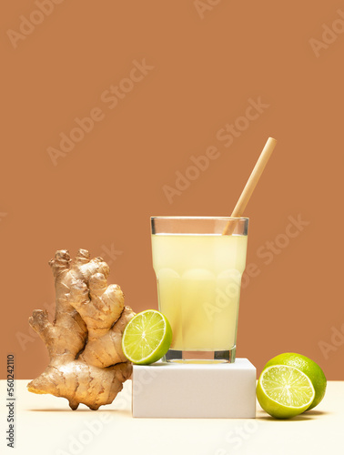 Ginger drink on white podium. Modern still life with Lime and ginger. Creative layout - refreshing ginger drink and lime. Creative summer concept. 