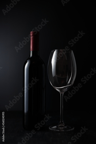 Empty Wine glass and Bottle on dark background.