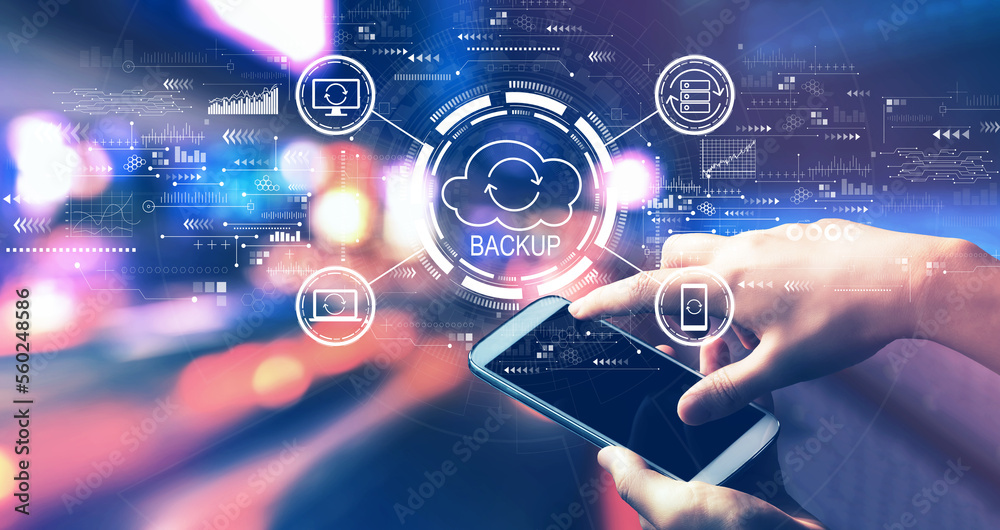Backup concept with person using a smartphone in a city at night Backup concept with person using a smartphone in a city at night