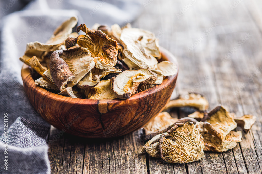 Sliced dried mushrooms in bowl on wooden table. Sliced dried mushrooms in bowl on wooden table.