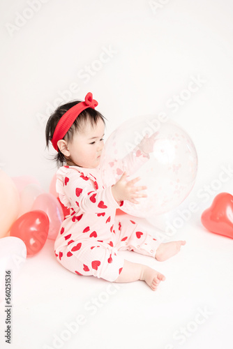 baby with valentine's heart shaped balloons