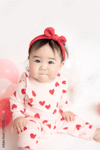 baby with valentine's heart shaped balloons