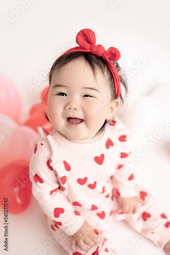 baby with valentine's heart shaped balloons