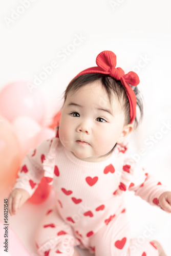 baby with valentine's heart shaped balloons