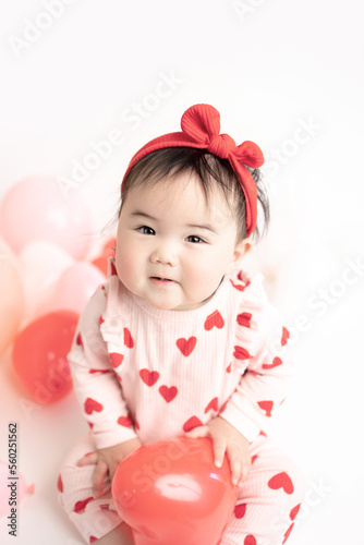 baby with valentine's heart shaped balloons