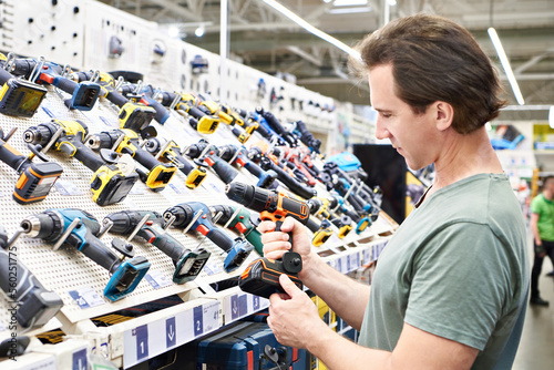 Fotografie Electric screwdriver in hand man in shop