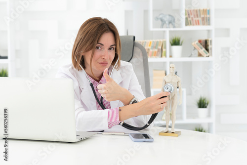 Young beautiful female doctor checking up with stethoscope a human model mock up in office of the clinic  © Vitaliy
