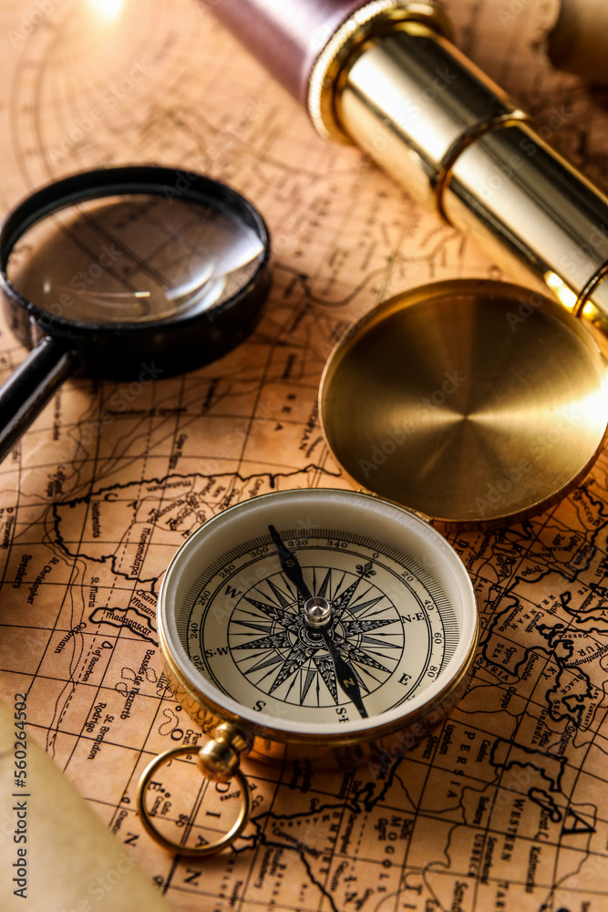 Golden compass, magnifier and spyglass on world map Golden compass, magnifier and spyglass on world map