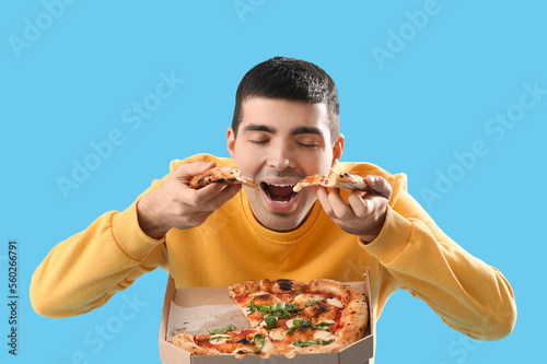Young man eating tasty pizz...