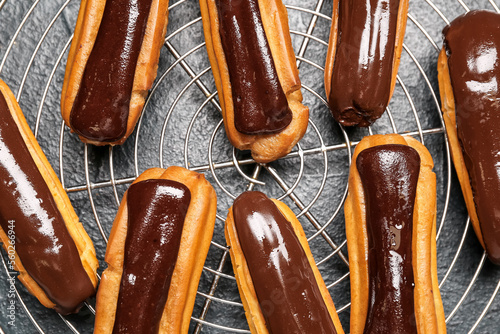 Foto Grid with tasty chocolate eclairs on dark color background
