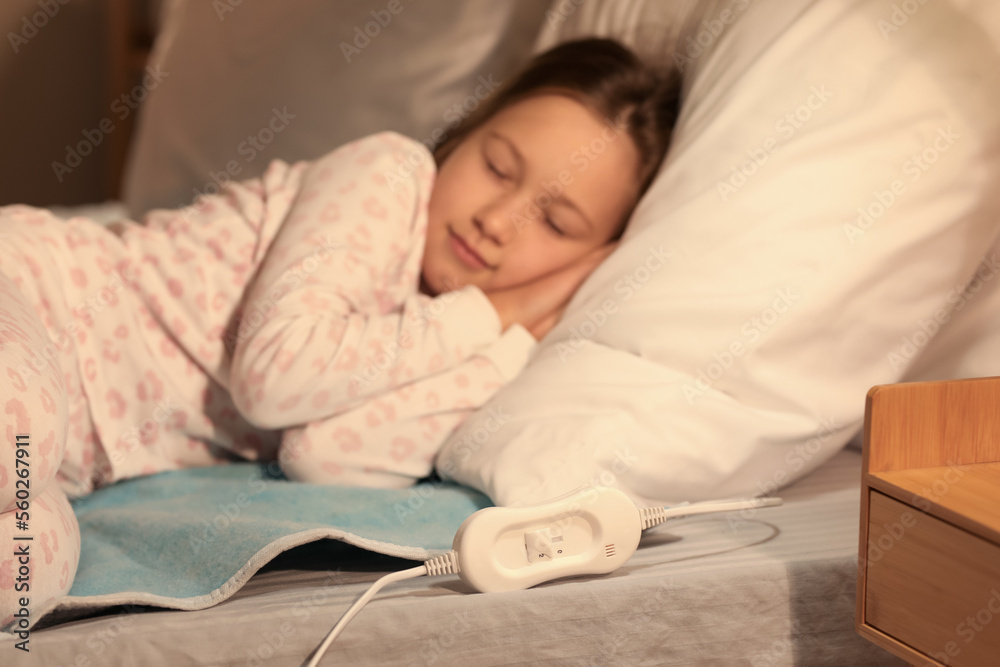 Little girl sleeping on electric heating pad in bedroom at night Little girl sleeping on electric heating pad in bedroom at night