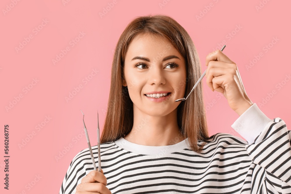 Young woman with dental tools on pink background, closeup Young woman with dental tools on pink background, closeup