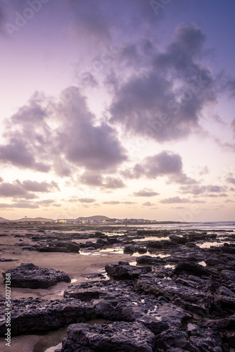 Fototapeta Naklejka Na Ścianę i Meble -  Sunset over the coastline of Famara beach on the Atlantic Ocean in Lanzarote, Canary Islands,  Spain