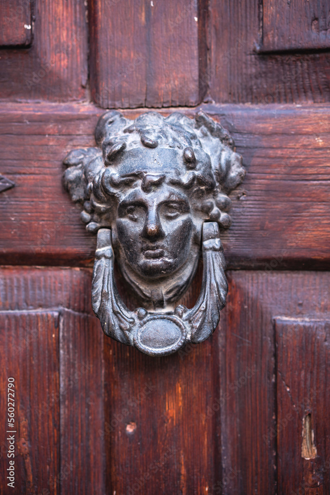 Metal door knocker with a human face