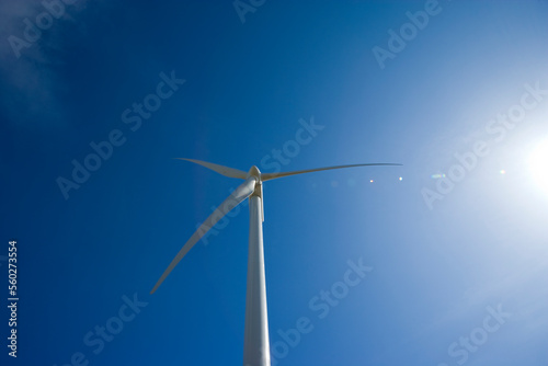 Wind turbine against a blue sky and sun © Robert Pennington