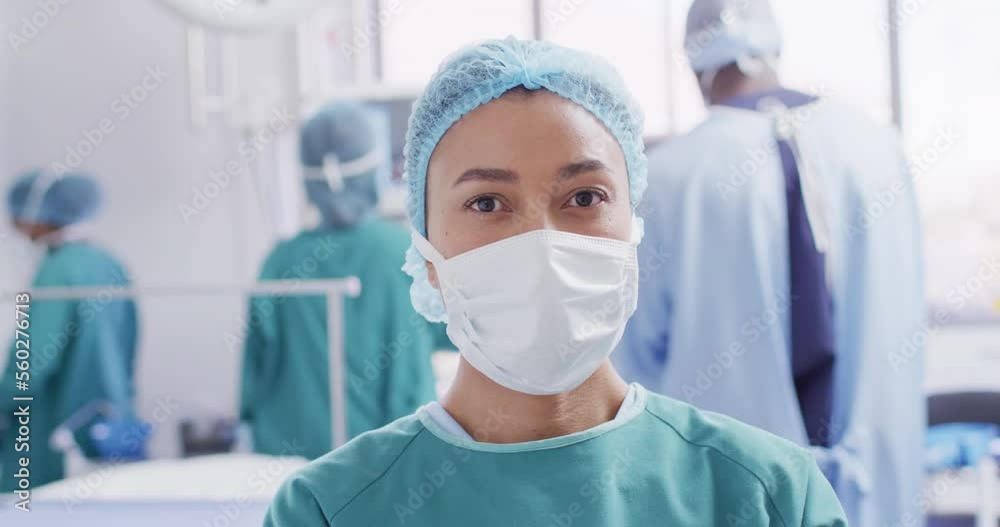 Video portrait of biracial female surgeon in face mask in operating theatre, with copy space Video portrait of biracial female surgeon in face mask in operating theatre, with copy space