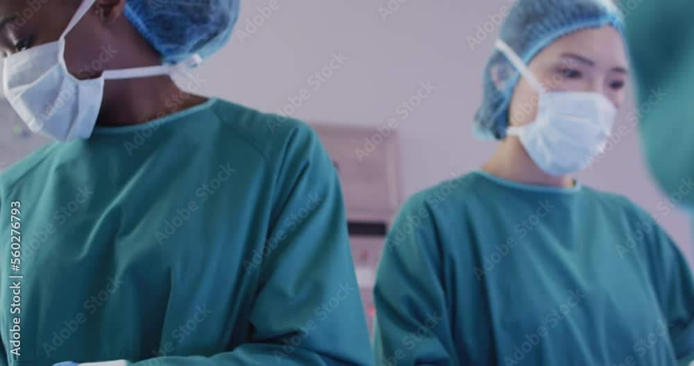 Video of diverse female surgeon and surgical assistants passing instruments during operation