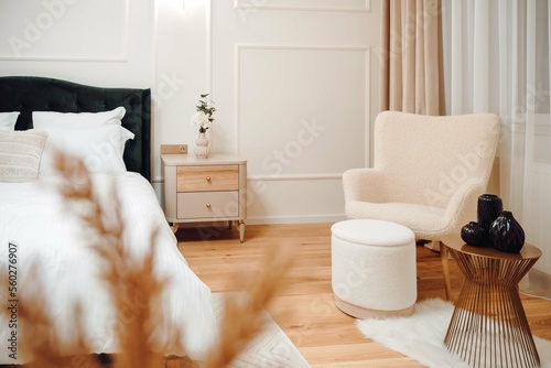 Luxury and stylish bedroom interior with king size bed, white bedding and modern light fixtures and beautiful nightstands