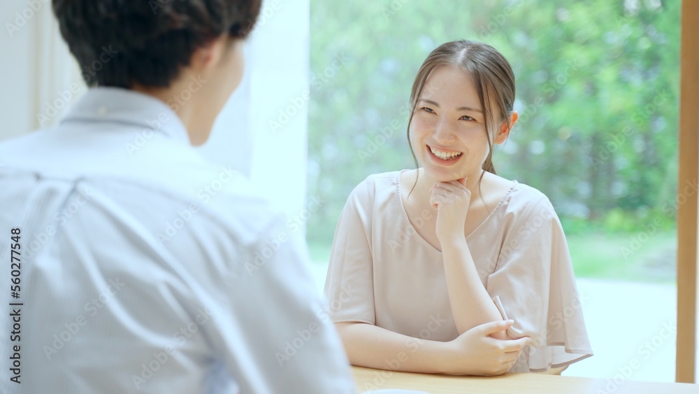 リビングで雑談をする若い夫婦 リビングで雑談をする若い夫婦