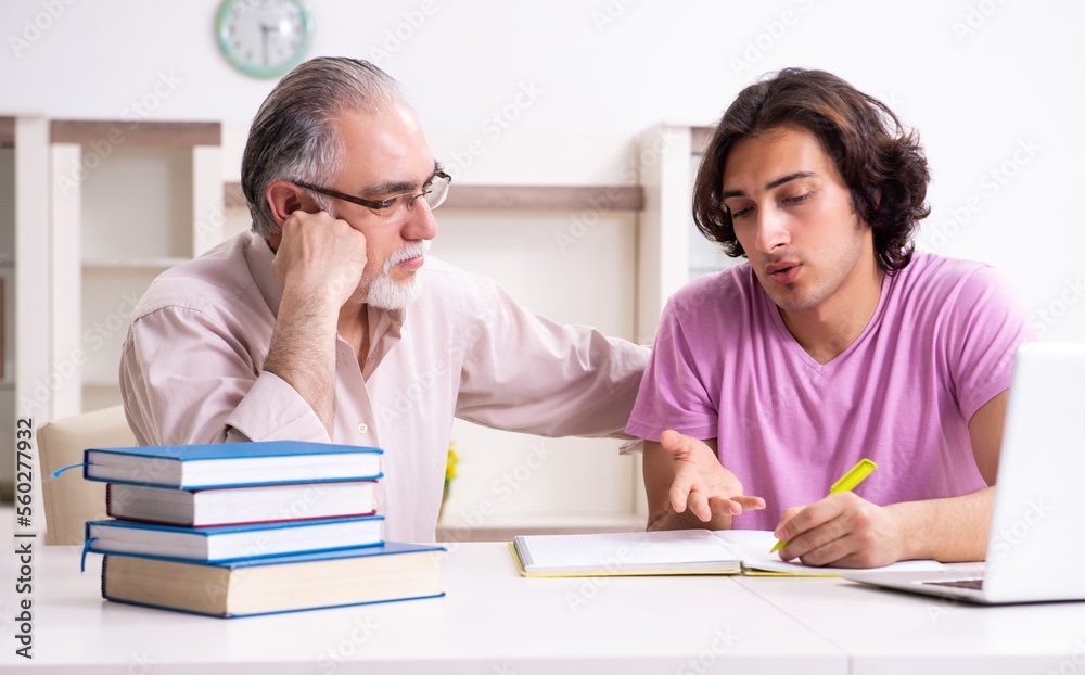 Old father helping his son in exam preparation